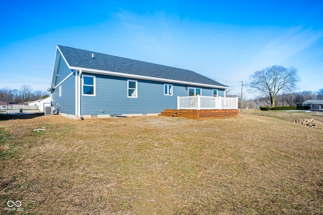 rear view of property with a lawn, central air condition unit, and a deck