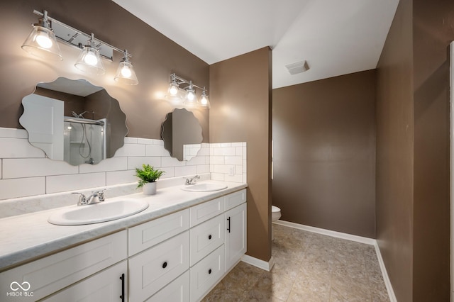 bathroom with tasteful backsplash, vanity, toilet, and walk in shower