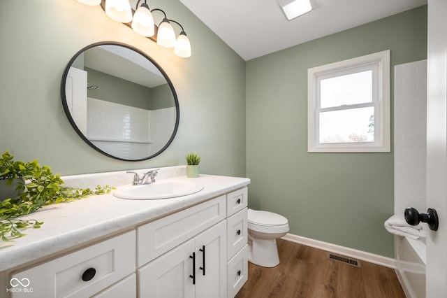 bathroom with hardwood / wood-style flooring, vanity, toilet, and walk in shower