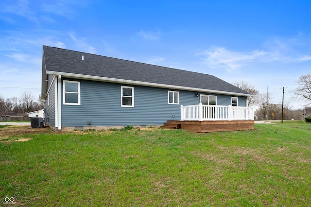 rear view of property featuring a shingled roof, a deck, central AC, and a lawn