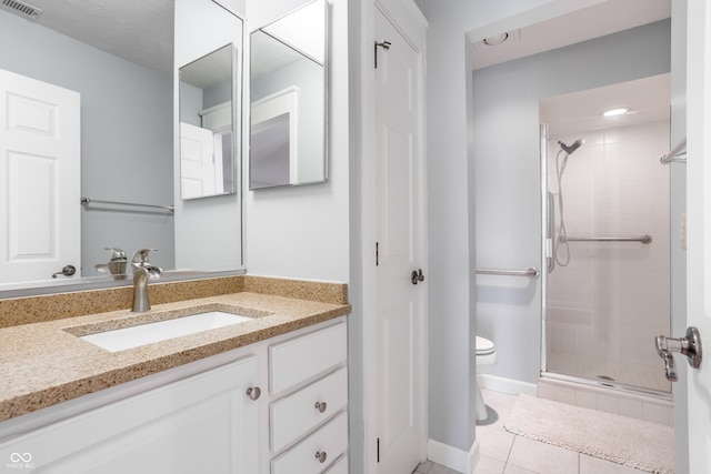 bathroom with tile patterned floors, toilet, a shower with shower door, and vanity