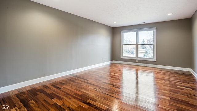 unfurnished room with wood-type flooring and a textured ceiling