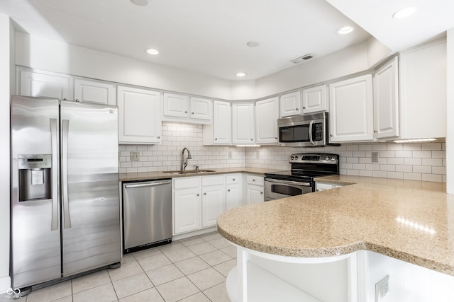 kitchen with sink, backsplash, white cabinets, and appliances with stainless steel finishes