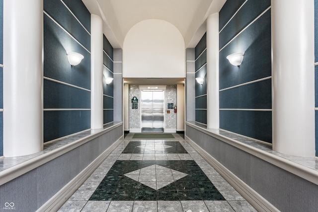 hall with vaulted ceiling and elevator