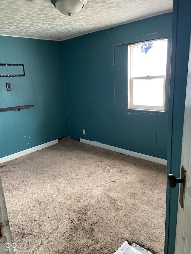 carpeted empty room featuring a textured ceiling