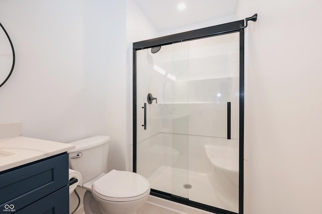 bathroom with vanity, toilet, and a shower with shower door