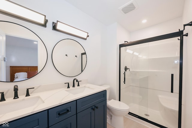 bathroom featuring vanity, a shower with shower door, and toilet