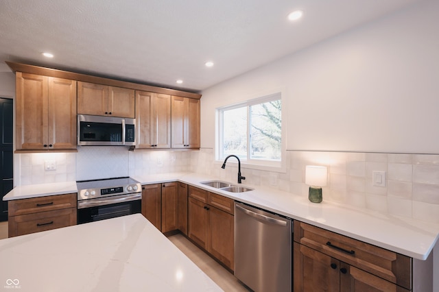 kitchen with tasteful backsplash, sink, and appliances with stainless steel finishes