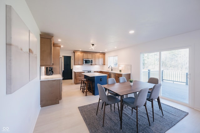 dining space with sink and light hardwood / wood-style floors