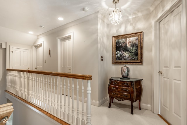 hallway with ornamental molding, a chandelier, and light carpet