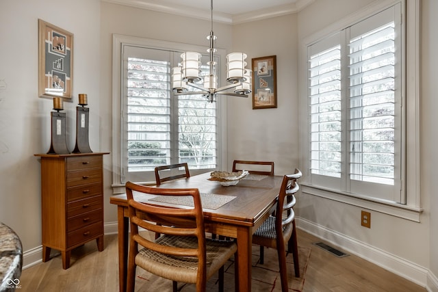 dining area featuring crown molding, light hardwood / wood-style floors, and a healthy amount of sunlight