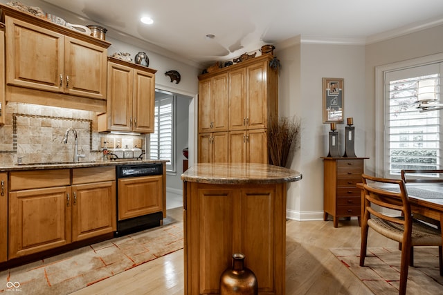 kitchen featuring sink, light hardwood / wood-style floors, light stone countertops, and a kitchen island