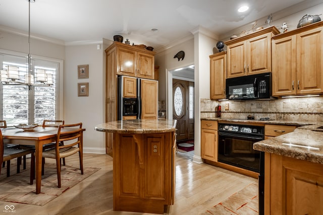 kitchen featuring decorative light fixtures, decorative backsplash, a center island, light hardwood / wood-style floors, and black appliances