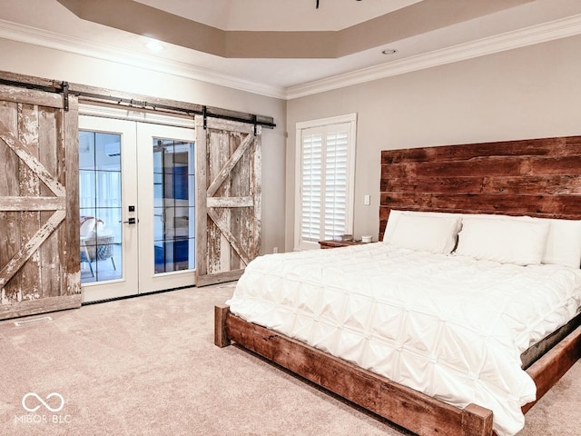 carpeted bedroom with crown molding, a tray ceiling, a barn door, and access to outside