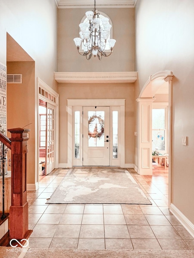 tiled foyer with an inviting chandelier and a towering ceiling