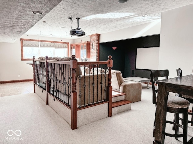 cinema room featuring light colored carpet and a textured ceiling