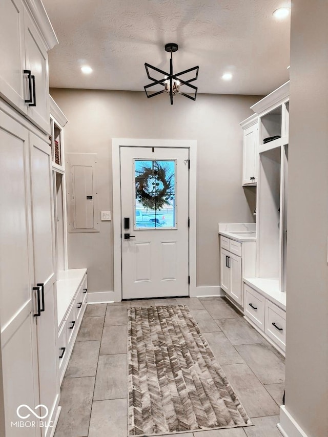 mudroom featuring electric panel and a textured ceiling