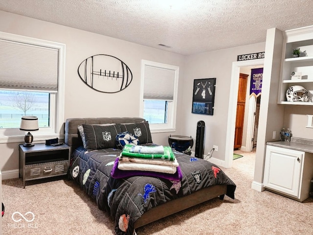 bedroom with light carpet and a textured ceiling