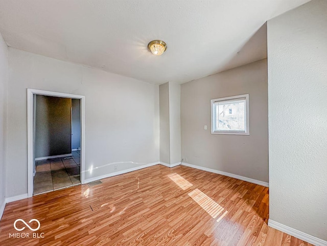 unfurnished room with wood-type flooring