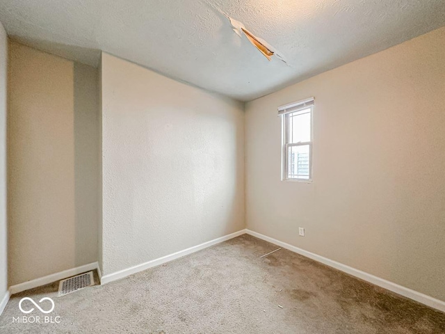 carpeted empty room with a textured ceiling