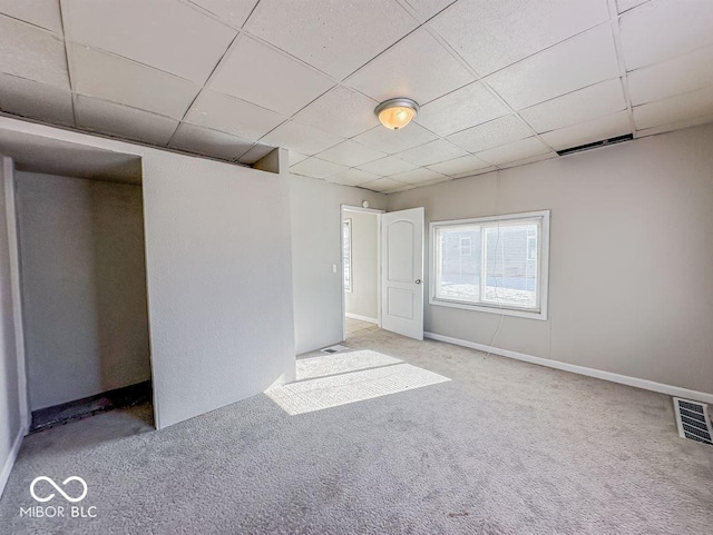 unfurnished room featuring light colored carpet and a paneled ceiling