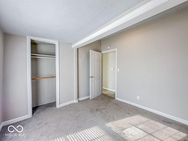 unfurnished bedroom with light colored carpet, a closet, and a textured ceiling