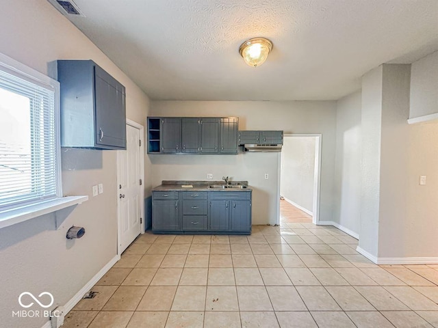 kitchen featuring light tile patterned floors, sink, and a textured ceiling