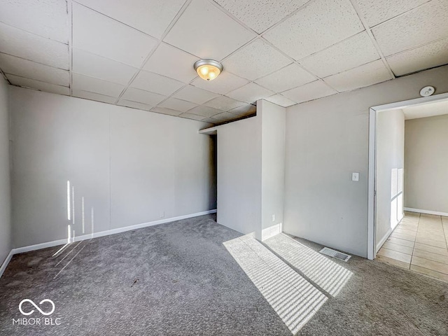 empty room with a paneled ceiling and carpet floors