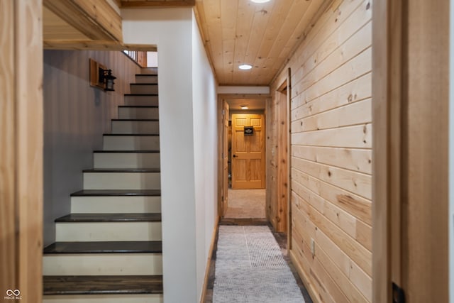 stairs with wood ceiling, wooden walls, and tile patterned floors