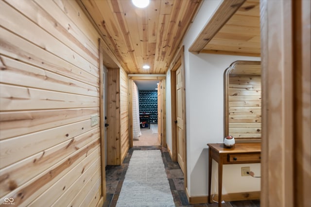 hallway featuring wooden ceiling and wood walls