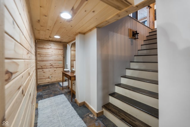 interior space featuring wooden ceiling and wood walls