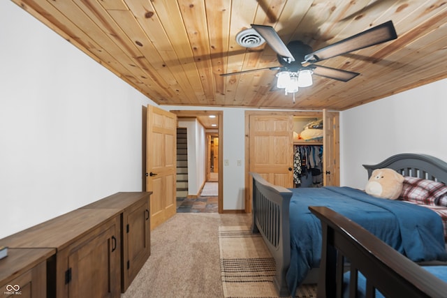 carpeted bedroom with ceiling fan, wood ceiling, and a closet