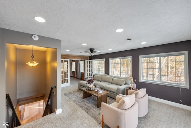 carpeted living room with french doors and a textured ceiling