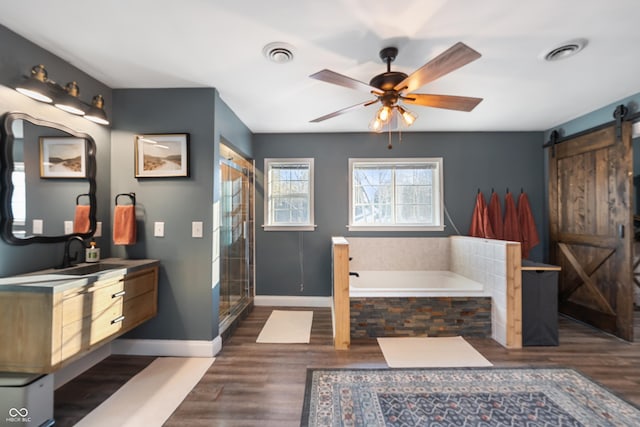 bathroom with vanity, wood-type flooring, plus walk in shower, and ceiling fan