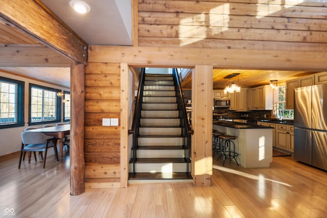 stairs featuring a notable chandelier, wood-type flooring, and sink