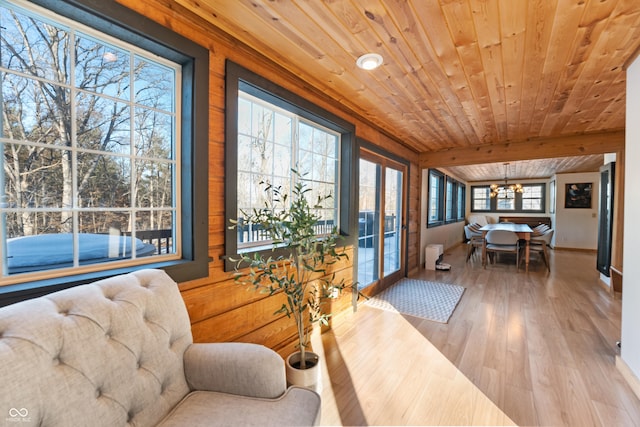 interior space featuring beam ceiling, wood ceiling, a wealth of natural light, and a chandelier