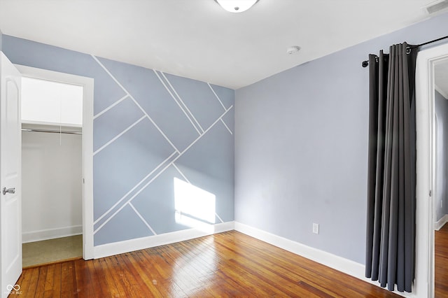 unfurnished bedroom featuring hardwood / wood-style floors and a closet