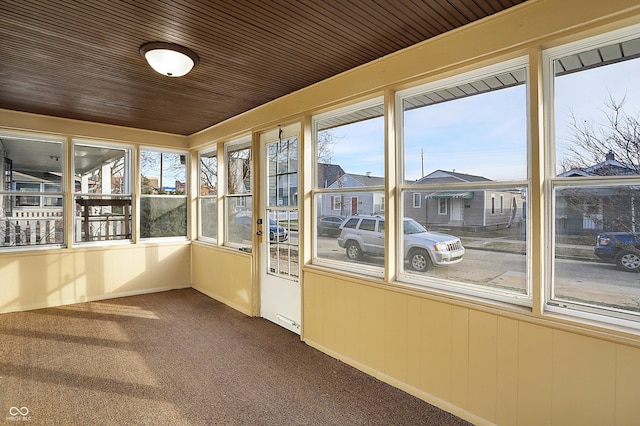 unfurnished sunroom featuring plenty of natural light and wooden ceiling