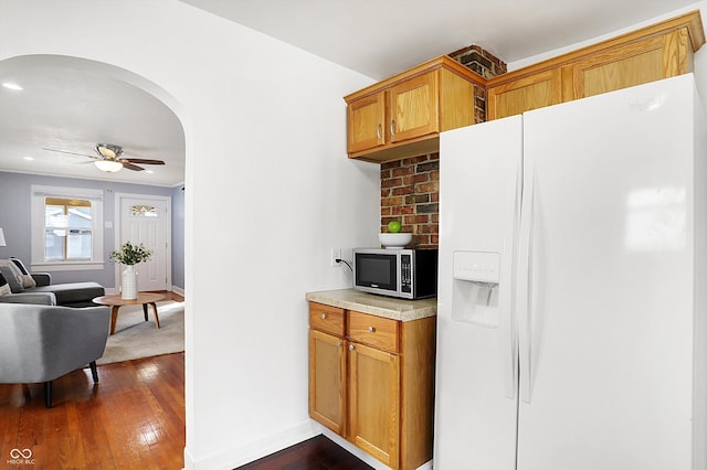 kitchen with dark hardwood / wood-style floors, white fridge with ice dispenser, and ceiling fan