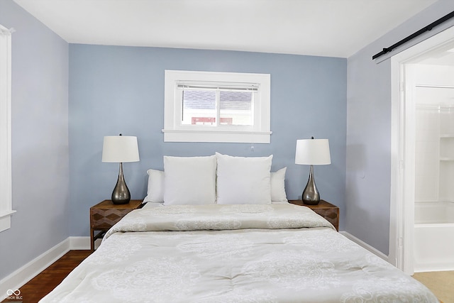 bedroom featuring dark wood-type flooring and a barn door