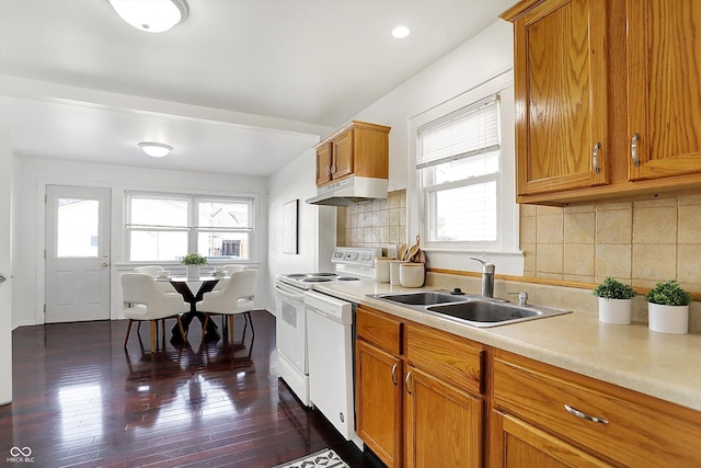 kitchen with dark wood-type flooring, white appliances, sink, and tasteful backsplash