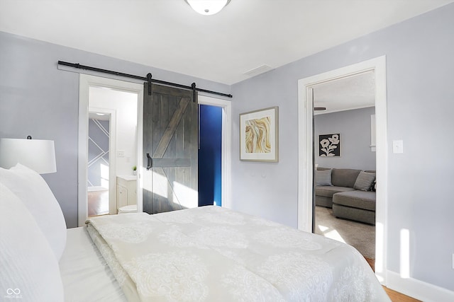 bedroom with a barn door and carpet floors