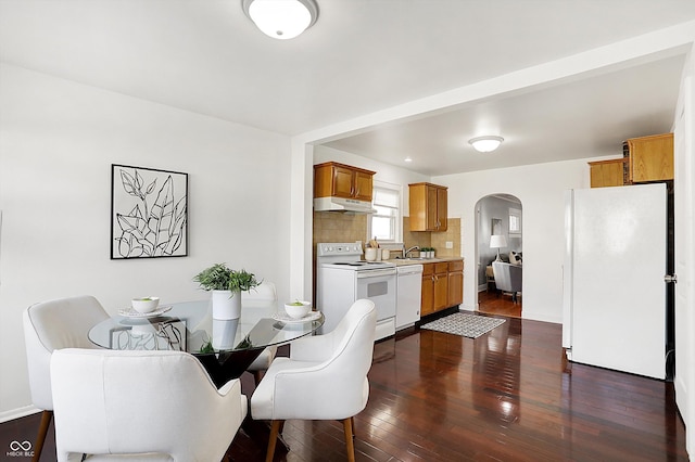 dining space with dark hardwood / wood-style flooring and sink