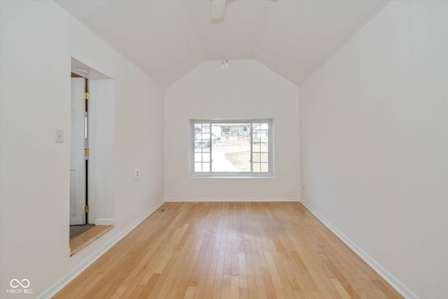 empty room with vaulted ceiling and light hardwood / wood-style floors