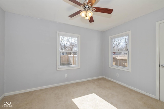 spare room with ceiling fan and light colored carpet