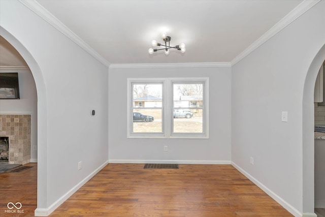 unfurnished dining area featuring crown molding, hardwood / wood-style flooring, and a fireplace