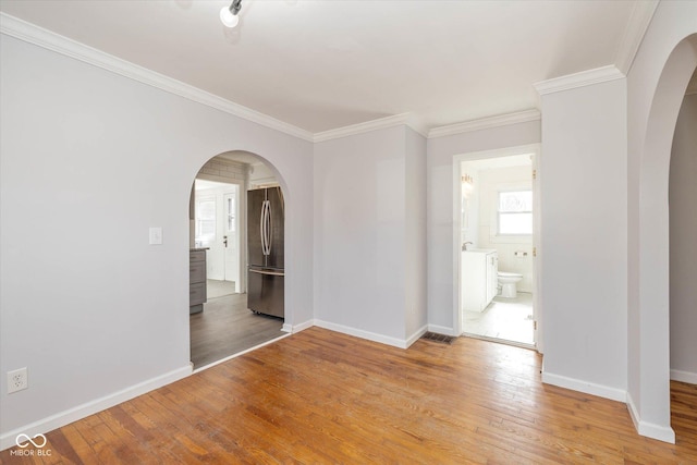 unfurnished room featuring wood-type flooring and ornamental molding