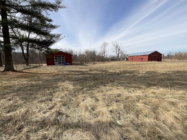 view of yard featuring a rural view and an outdoor structure