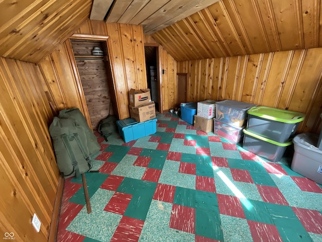 bonus room with wooden walls and vaulted ceiling