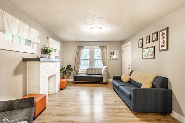 361 S Spencer Ave, Indianapolis, IN 46219 - living area with light wood finished floors, a textured ceiling, baseboards, and a brick fireplace